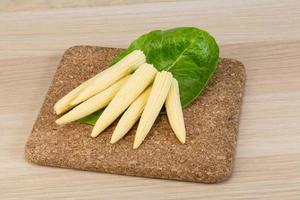 Baby corn on wooden board and wooden background photo