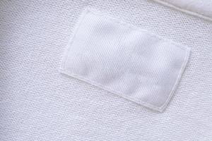 Blank white clothes label on new shirt background photo