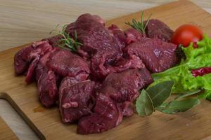 Raw venison on wooden board and wooden background photo