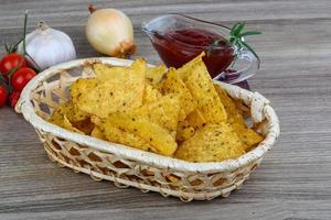 Nachos in a basket on wooden background photo