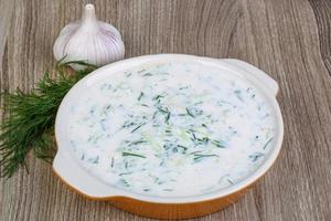 Tzatziki in a bowl on wooden background photo