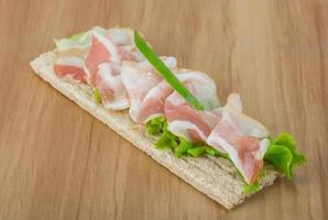 Bacon sandwich on wooden board and wooden background photo