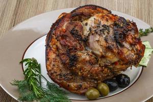 Pork knee on the plate and wooden background photo