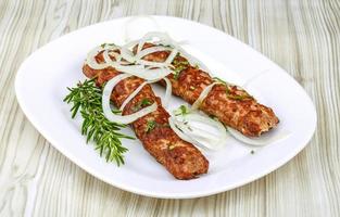 Beef kebab on the plate and wooden background photo