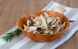 shiitake seco en un recipiente sobre fondo de madera foto