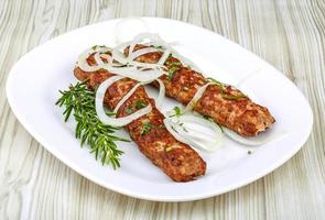 Beef kebab on the plate and wooden background photo