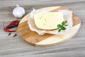 Cheese on wooden board and wooden background photo