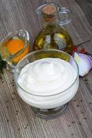 Mayonnaise sauce in a bowl on wooden background photo