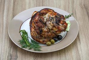 Pork knee on the plate and wooden background photo