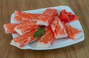 Crab sticks on the plate and wooden background photo