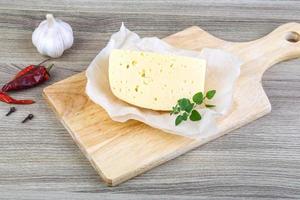 Cheese on wooden board and wooden background photo