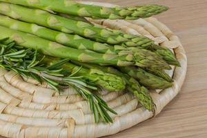 Raw asparagus on wooden board and wooden background photo