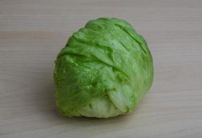 Iceberg salad on wooden board and wooden background photo