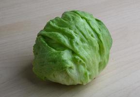 Iceberg salad on wooden board and wooden background photo