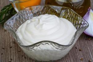 Mayonnaise sauce in a bowl on wooden background photo