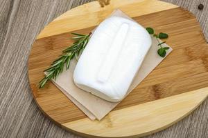 Feta cheese on wooden board and wooden background photo