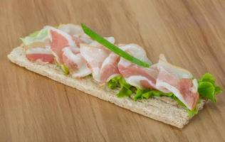 Bacon sandwich on wooden board and wooden background photo