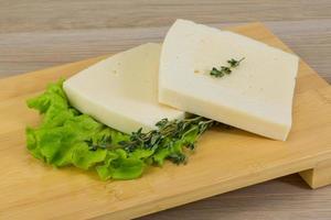 Yellow cheddar on wooden board and wooden background photo