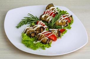 Eggplant roll on the plate and wooden background photo