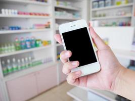 mujeres que usan teléfonos inteligentes en la farmacia fondo borroso foto