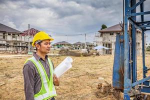 trabajador de ingeniero de construcción de hombre de negocios asiático en el sitio de construcción de viviendas foto