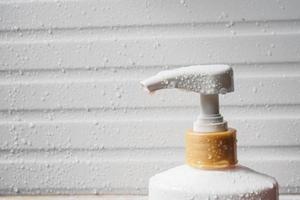 Water drop on liquid soap dispenser pump during bath time photo