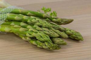 Raw asparagus on wooden background photo