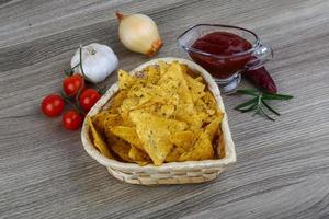 Nachos in a basket on wooden background photo