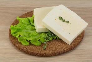 Yellow cheddar on wooden board and wooden background photo