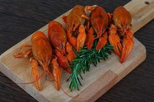 Crayfish on wooden board and wooden background photo