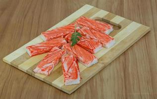 Crab sticks on wooden board and wooden background photo