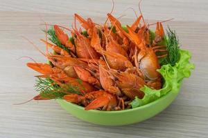 Boiled crayfish in a bowl on wooden background photo