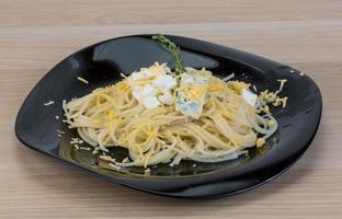 Cheese pasta on the plate and wooden background photo