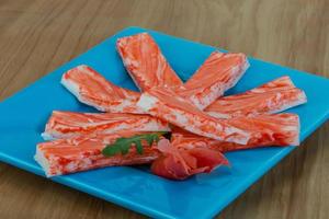 Crab sticks on the plate and wooden background photo