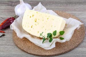 Cheese on wooden board and wooden background photo