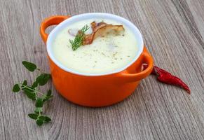 Cheese soup in a bowl on wooden background photo