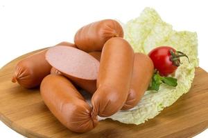 Sausages on wooden board and white background photo