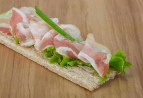 Bacon sandwich on wooden board and wooden background photo