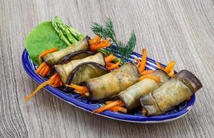 Eggplant rolls in a bowl on wooden background photo