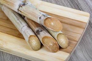 palitos de azúcar en tablero de madera y fondo de madera foto