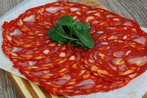 Chorizo sausage on wooden board and wooden background photo