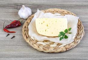 Cheese on wooden board and wooden background photo