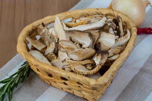 shiitake seco en una cesta sobre fondo de madera foto