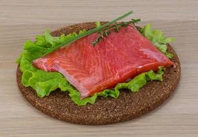 Salmon on wooden board and wooden background photo