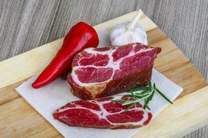 Chuck steak on wooden board and wooden background photo