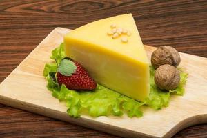 Parmesan cheese on wooden board and wooden background photo