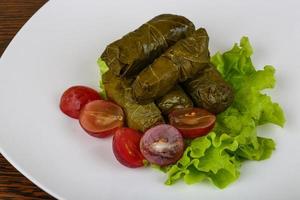 Dolma on the plate and wooden background photo