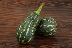 Green pumpkin on wooden background photo