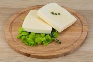 Yellow cheddar on wooden board and wooden background photo