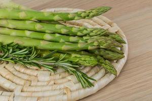 Raw asparagus on wooden board and wooden background photo
